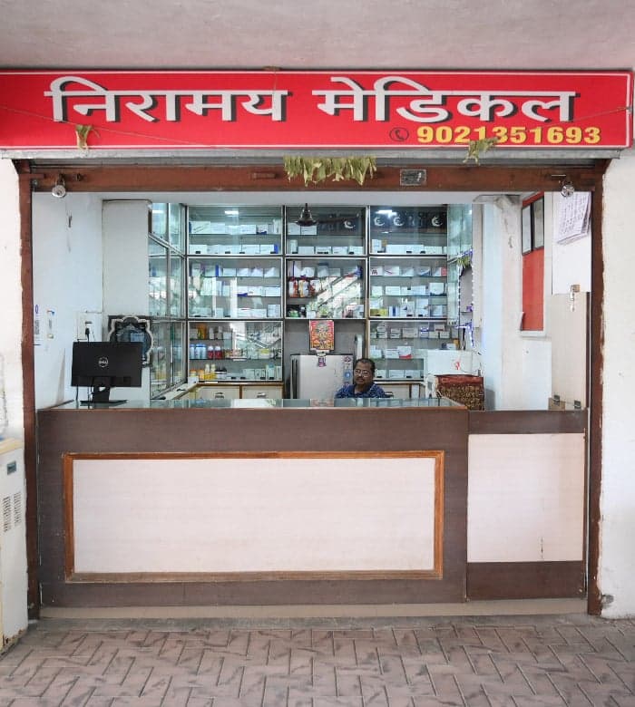 The in-house Niramay Pharmacy counter with stocked medicine shelves
